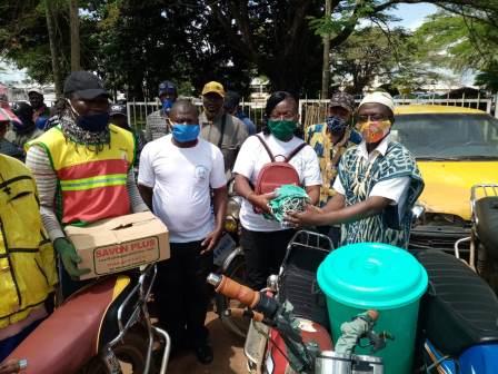 Mme Ngono Abanda remettant des kits aux conducteurs de motos de l'arrondissement de Yaoundé VI.