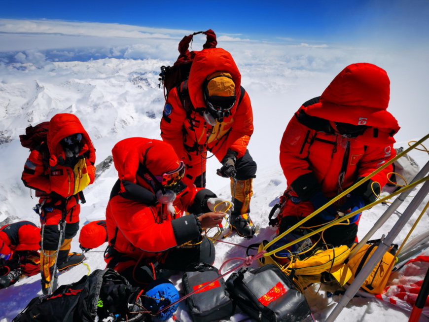 Chinese surveyors conduct surveying atop Mount Qomolangma, May 27, 2020. (Photo by Tashi Tsering, special correspondent of Xinhua News Agency)