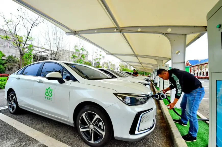 A man charges an electric vehicle at a charging station in Yueliangwan new district, Huichang county, Ganzhou of Jiangxi province in east China, March 27. (Photo by Zhu Haipeng, People’s Daily Online)