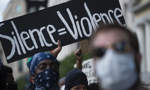 Demonstrators protesting the death of George Floyd hold up placards up near the White House on in Washington, DC. Photo: AFP