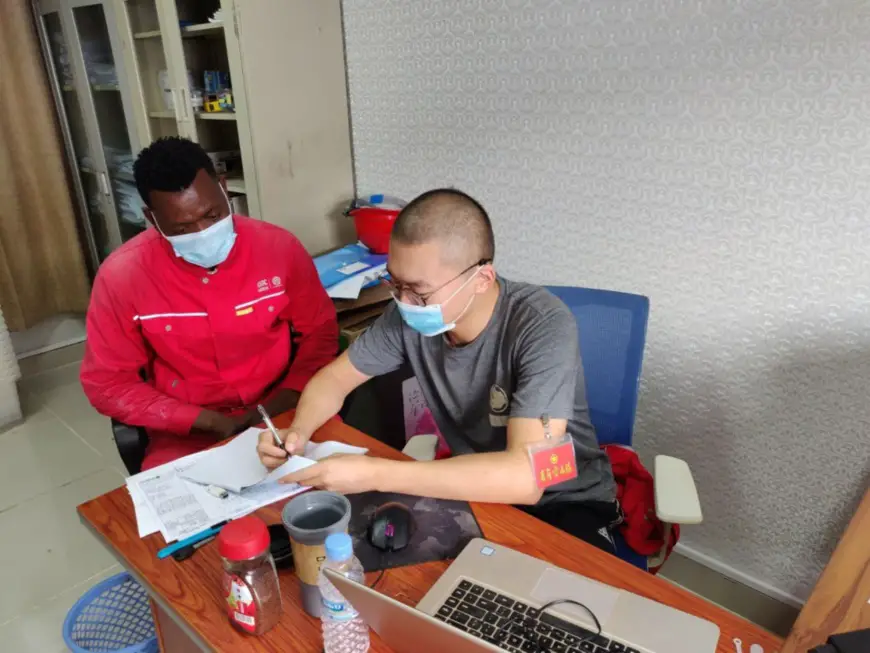 A Chinese employee of CGGC’s Caculo Cabaca hydropower project in Angola explains instruction on medical supplies to a local employee.