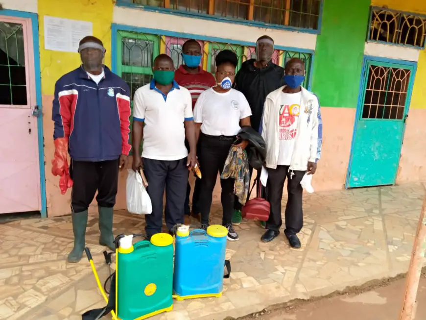 Mme Ngono Abanda Scholastique (en tricot blanc) avec l'équipe des agents de désinfection dans un établissement scolaire.