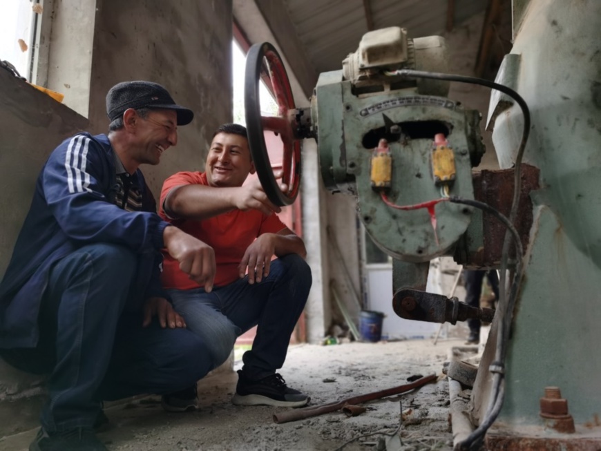 Amirjan (right) checks equipment at a hydropower station in Datong Township with his coworker on June 28. Photo by Li Ya’nan/People’s Daily Online