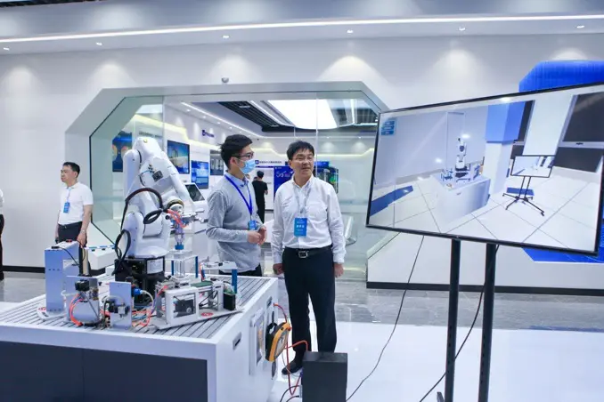 Engineers from enterprises in the Changzhou big data industrial park in east China’s Jiangsu province introduce an industrial robot, May 18. (Photo by Shi Kang/People’s Daily Online)