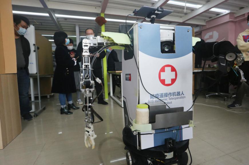 An anti-epidemic teleoperation robot developed by the College of Artificial Intelligence under China's Nankai University displays how it works, April 1. The robot can be controlled by mobile phones, and is able to measure temperature, serve as a hospital guide, disinfect, and transfer samples. Besides, it can also inspect the wards with the cameras installed, and help the doctors launch remote consultation. Photo by Liu Dongyue/ People's Daily Online An anti-epidemic teleoperation robot developed by the College of Artificial Intelligence under China's Nankai University displays how it works, April 1. The robot can be controlled by mobile phones, and is able to measure temperature, serve as a hospital guide, disinfect, and transfer samples. Besides, it can also inspect the wards with the cameras installed, and help the doctors launch remote consultation. Photo by Liu Dongyue/ People's Daily Online