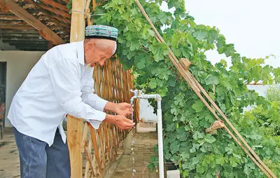 Yimiti Esan washes his hands with a faucet in his yard. People's Daily/Li Ya'nan