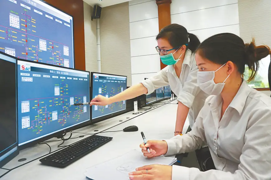 Chinese and Lao employees monitor device operation at the centralized control center of the Nam Ou River Cascade Hydropower Project. People's Daily/Sun Guangyong