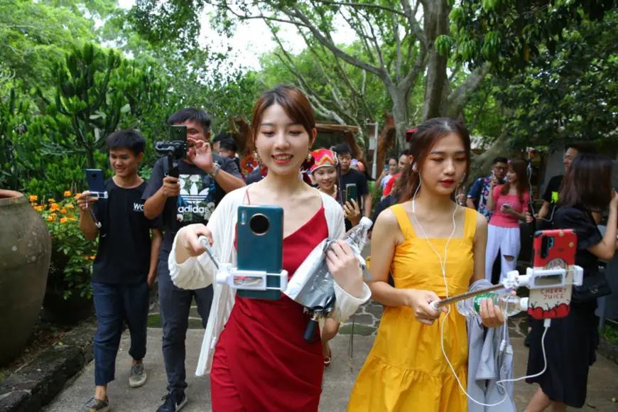 Photo taken on June 25 shows popular livestreaming hosts introducing a scenic spot in Haikou, capital of South China’s Hainan Province. Photo by Zhang Mao/People’s Daily Online