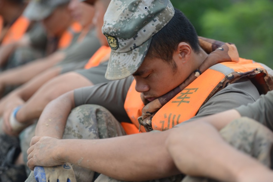 Chinese People’s Liberation Army soldiers take a rest during flood rescue in Yingshang county, east China’s Anhui province, July 26. (Photo by Dai Wenxue/People’s Daily Online)