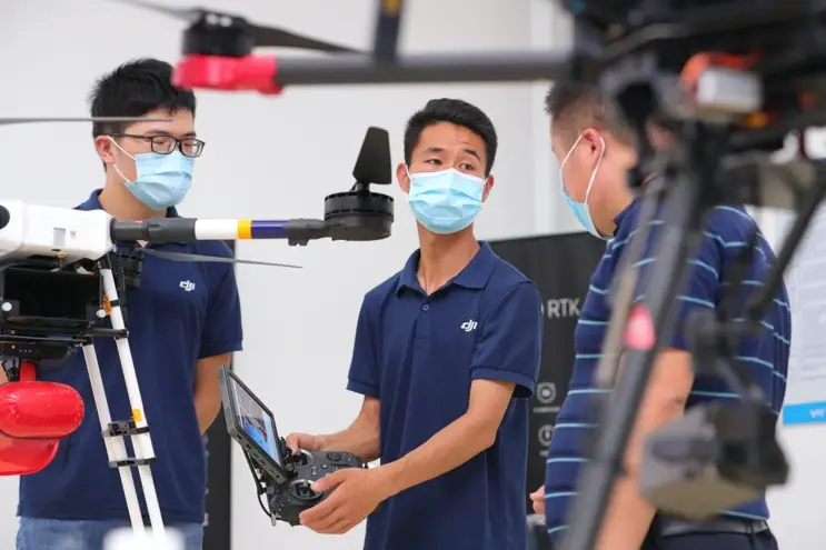 An employee of Chinese drone maker DJI introduces the company's product in an industrial park in Tianjin which is opened on July 30. Photo by Shen Yue/People's Daily Online