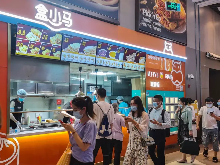 Photo shows customers scanning QR code to take meals from a thermal cabinet of a Hexiaoma store in Shanghai, July 20. (Photo by Wang Gang/People’s Daily Online)