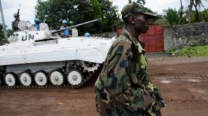 Un rebelle du M23 qui passe devant un char de l'ONU. Crédits photos : sources. Un rebelle du M23 qui passe devant un char de l'ONU. Crédits photos : sources.