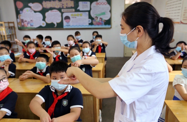 A nurse shows students how to wash their hands at a primary school in Lianyungang, East China’s Jiangsu Province on Sept. 1. Photo by Wang Jianmin/People’s Daily Online