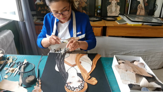 Photo shows Li Yanhong creates a bark painting. (Photo/wodsy.com)