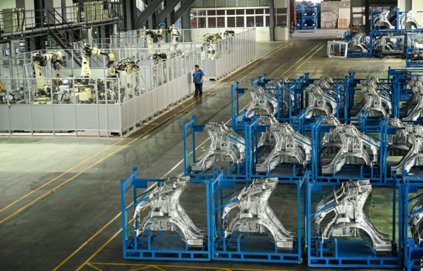 A worker inspects the work of robots in a digital workshop of an auto part manufacturer in Yubei district, southwest China’s Chongqing municipality, Aug. 18. Photo by Wan Nan, People’s Daily Online