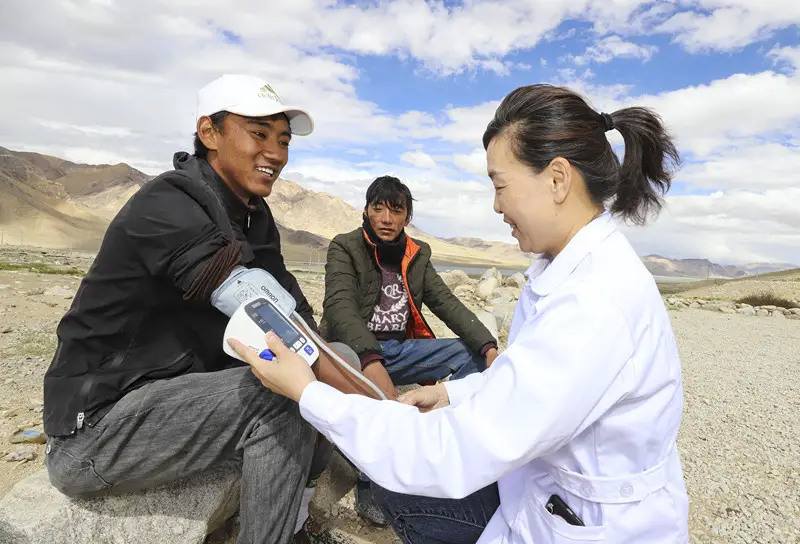 A doctor aiding Tibet Autonomous Region from Northwest China's Shaanxi Province measures blood pressure for a resident in Gar County, Southwest China's Tibet Autonomous Region on July 31. Photo by Liu Xiaodong/People's Daily Online