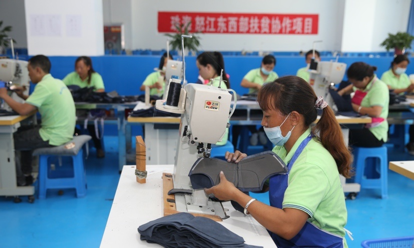 Workers make uppers at a poverty alleviation workshop in Nujiang Lisu autonomous prefecture, southwest China’s Yunnan province, October 14. (Photo by Liang Zhiqiang/People’s Daily Online)