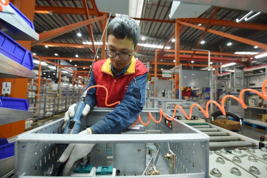 A worker assembles a smart power distribution cabinet at the State Grid Xiaoshan Electric Power Xinmei Electric Company in Hangzhou, East China's Zhejiang Province on October 19. Photo by Long Wei/People's Daily Online