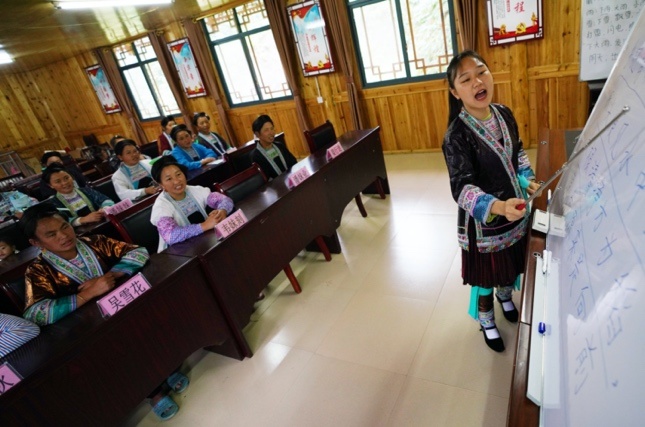 College volunteer Liang Mengxiang teach local women Mandarin in Rongshui Miao autonomous county, Liuzhou, Southwest China's Guangxi Zhuang Autonomous Region on June 3. Photo by Long Linzhi/People's Daily Online