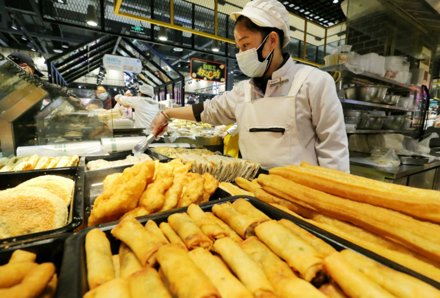 An employee of a supermarket makes pies for sale, Mar. 26. (Photo by Wang Jianmin/People's Daily Online)