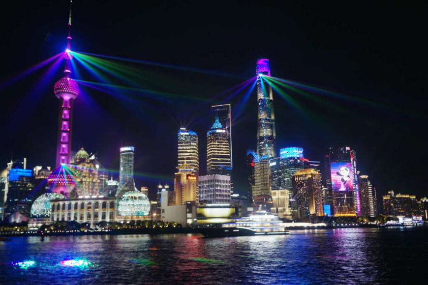 Photo taken on Nov. 4 shows a CIIE-themed light show staged beside the Huangpu River in Shanghai. The opening ceremony of the third CIIE was held in the city on that day. (Photo by Ma Weiqin/People's Daily Online)