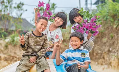 Children in Manbansandui hamlet, Xishuangbanna Dai autonomous prefecture, southwest China’s Yunnan province, smile happily in front of camera. (Photo/Xinhua)