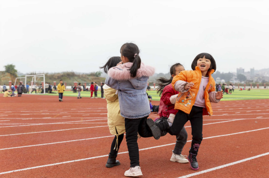 Students from a primary school in Qianxi county, Bijie, southwest China's Guizhou province play games on the playground, Nov. 5. The school was built for a poverty alleviation relocation site. It has ensured the education for students in the region and further consolidate poverty alleviation efforts. (Photo by Fan Hui/People's Daily)