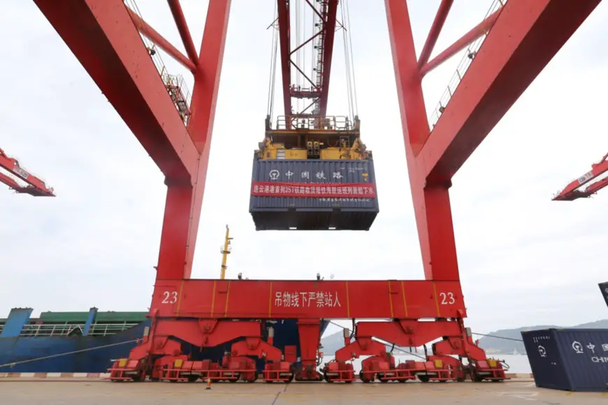 Lianyungang port in east China's Jiangsu province sees its first multimodal freight train that carries open top containers depart, June 30. The train makes it possible to transport coal products with railway containers on sea routes. Photo by Wang Jianmin/People's Daily Online