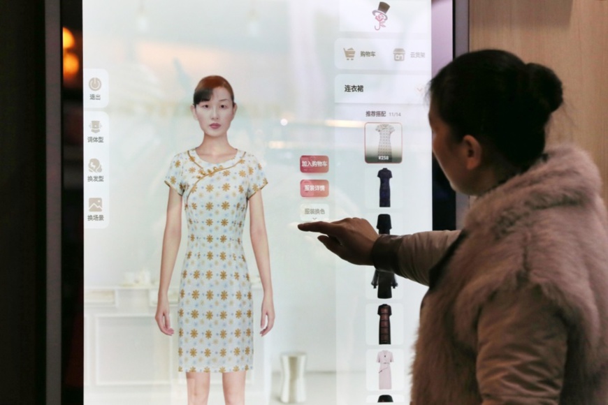 A customer tries on cloths with the help of a smart dressing mirror at Xiaohuagua Garment E-commerce Co., Ltd. in Suixi county, east China’s Anhui province. (Photo by Wan Shanchao/People’s Daily Online) A customer tries on cloths with the help of a smart dressing mirror at Xiaohuagua Garment E-commerce Co., Ltd. in Suixi county, east China’s Anhui province. (Photo by Wan Shanchao/People’s Daily Online)