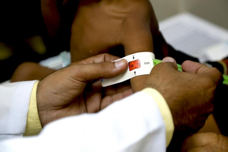 © UNICEF/UN0276428/Almahbashi | Salim est de 7 mois, est examiné par mesure la circonférence du bras supérieur pour vérifier la malnutrition.