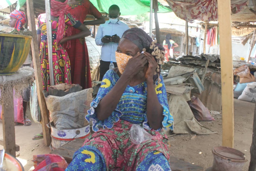 Une femme porte un masque qui lui a été offert, dans un marché de N'Djamena. © Ben Kadabio/Alwihda Info Une femme porte un masque qui lui a été offert, dans un marché de N'Djamena. © Ben Kadabio/Alwihda Info