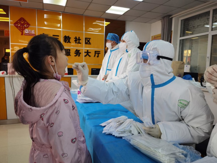 A girl receives COVID-19 nucleic acid test at a designated testing site in Shijiazhuang, north China’s Hebei province, Jan. 6. (Photo by Lv Lining/People’s Daily Online)