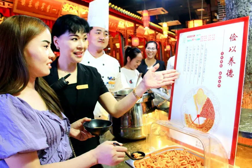 An employee of a hotpot restaurant in Huaibei, eat China’s Anhui province, guides customers to fetch food in accordance with actual needs, Sept. 4, 2020. (Photo by Zhou Fangling/People’s Daily Online)