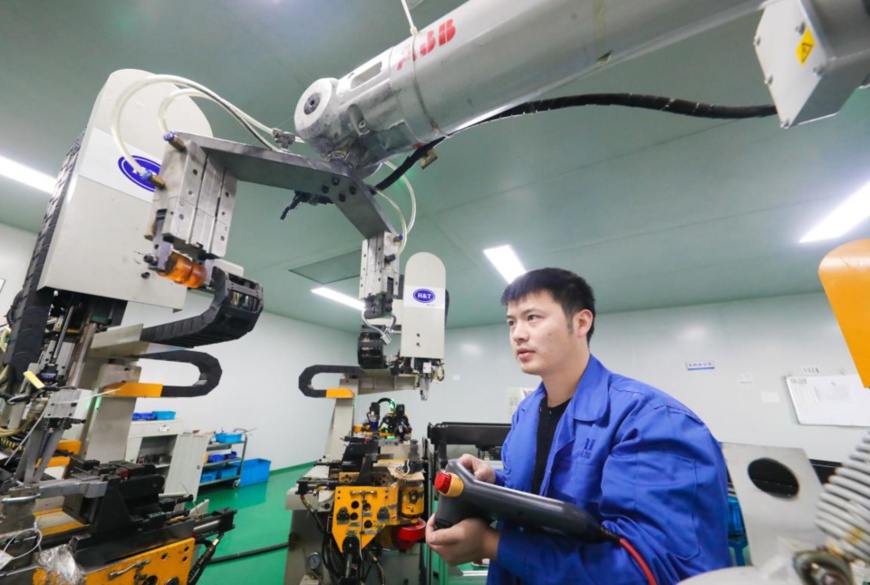 A worker manufactures products to be shipped overseas at an auto parts company in Huzhou, east China's Zhejiang province, Jan. 13, 2021. (Photo by Wang Zheng/People's Daily Online)