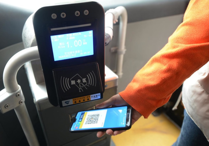 A passenger pays for bus ticket on Mianfangxi Road, Zhengzhou, central China's Henan province, March 16, 2020. (Photo by Zhang Tao/People's Daily Online)