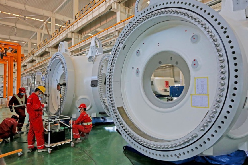 Photo shows workers assembling wind turbines in a company based in Hami, northwest China’s Xinjiang Uygur autonomous region. (Photo by Cai Zengle/People’s Daily Online)