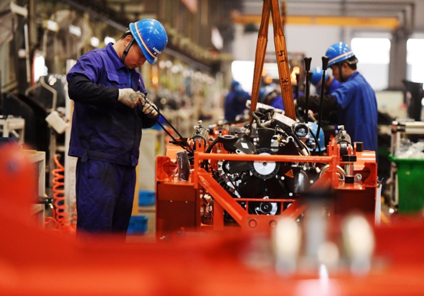 Workers manufacture forklifts on a production line of Lonking (Jiangxi) Machinery Co., Ltd., Jan. 27, 2021. (Photo by Zhou Liang/People's Daily Online)