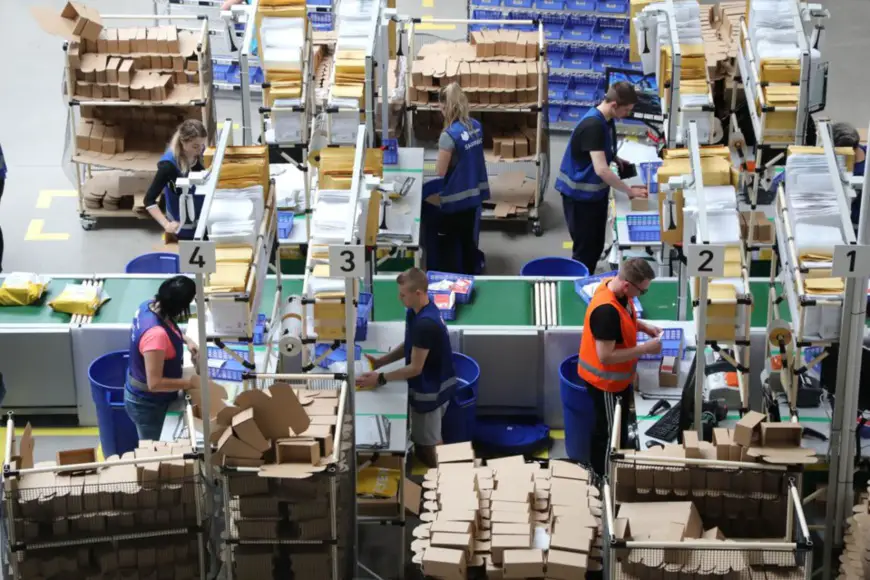 Workers package goods and attach courier receipts to parcels at a warehouse of MBB logistics, a Polish-Chinese company that offers logistics services to e-commerce companies, in Slubice, Poland. (Photo by Li Qiang/People's Daily)