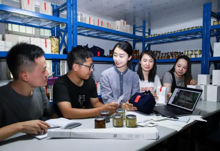 Photo shows Hu Tingting, a college graduate who returned to her hometown in Dayuan village, Tongling, east China’s Anhui province, and created her own white ginger brand, discussing about the packaging and sales of the product with her colleagues. (Photo by Chen Chen/People’s Daily Online)
