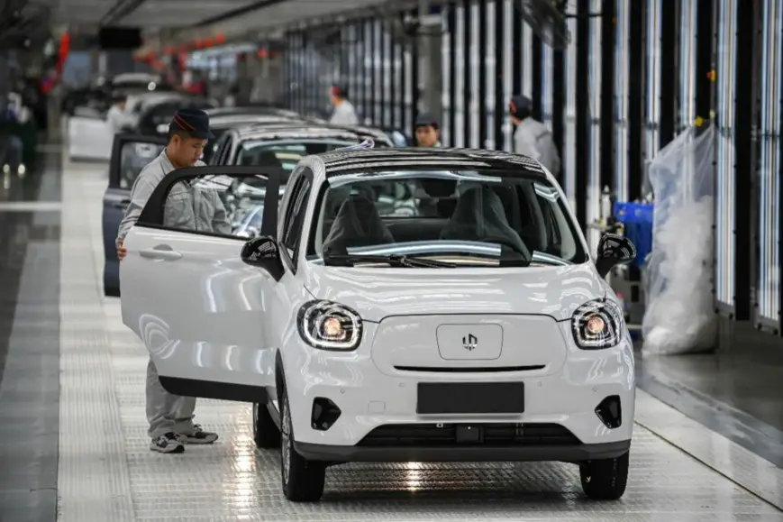 Staff members of Leap Motor, a Chinese automobile manufacturer, check quality of new energy vehicles that have just rolled off production line at a workshop in Jinhua, east China's Zhejiang Province, March 24, 2021. (Photo by Hu Xiaofei/People's Daily Online)