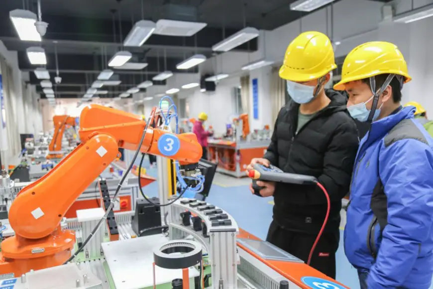 Students control a robot at the industrial robot practical training center of a vocational school in Xinqiao township, Songjiang district, east China’s Shanghai, March 7, 2021. (Photo by Jiang Huihui/People’s Daily Online)