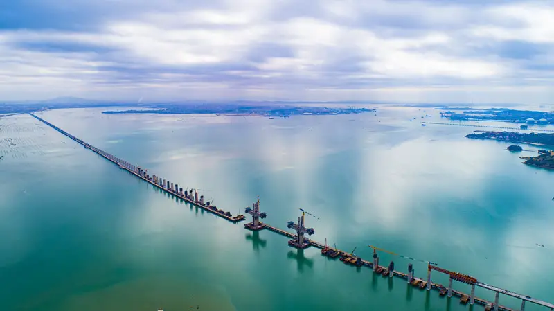 The Meizhou Bay cross-sea bridge of the Fuzhou-Xiamen high-speed railway in Quanzhou, southeast China's Fujian Province, is under construction, March 26, 2021. (Photo by Jin Wei/People's Daily Online)