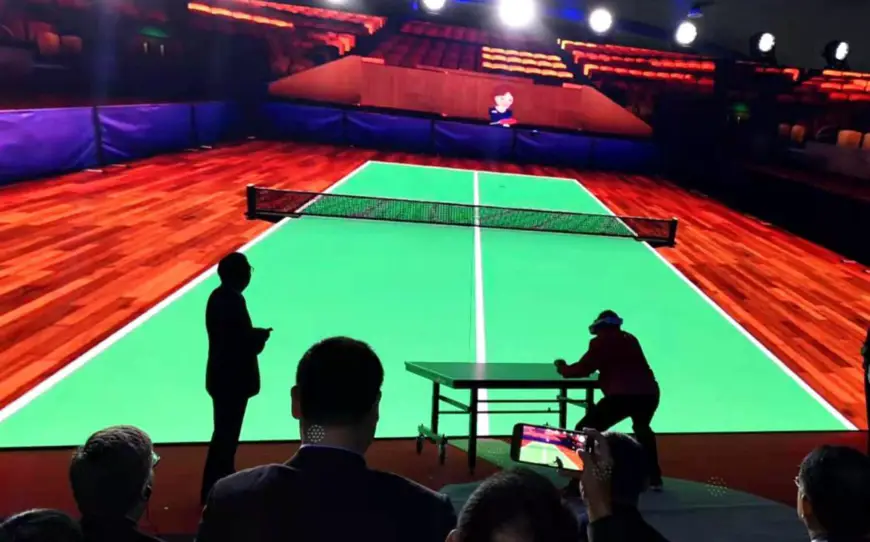 Liang Geliang, a former world champion from China, plays table tennis with Judy Hoarfrost, who has been inducted into the U.S. Table Tennis Hall of Fame and visited China in 1971, in a VR game at the Shougang Park, Beijing, April 24, 2021. (Photo by Li Yan/People’s Daily)