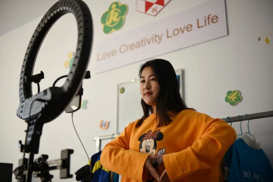 An employee of an innovation and entrepreneurship center for persons with disabilities in Xuanhua District, Zhangjiakou, North China's Hebei Province sells commodities on a livestream show with sign language, Dec. 3, 2020. (Photo by Chen Xiaodong/People's Daily Online)