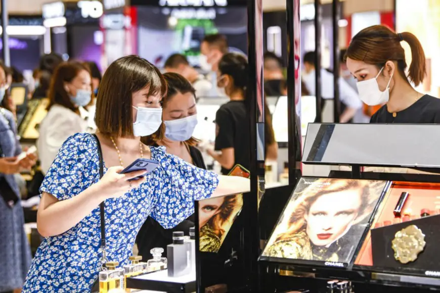 A woman buys cosmetics products at a duty-free shop under China Duty Free Group in Haikou, South China's Hainan Province, April 20, 2021. (Photo by Kang Denglin/People's Daily Online)