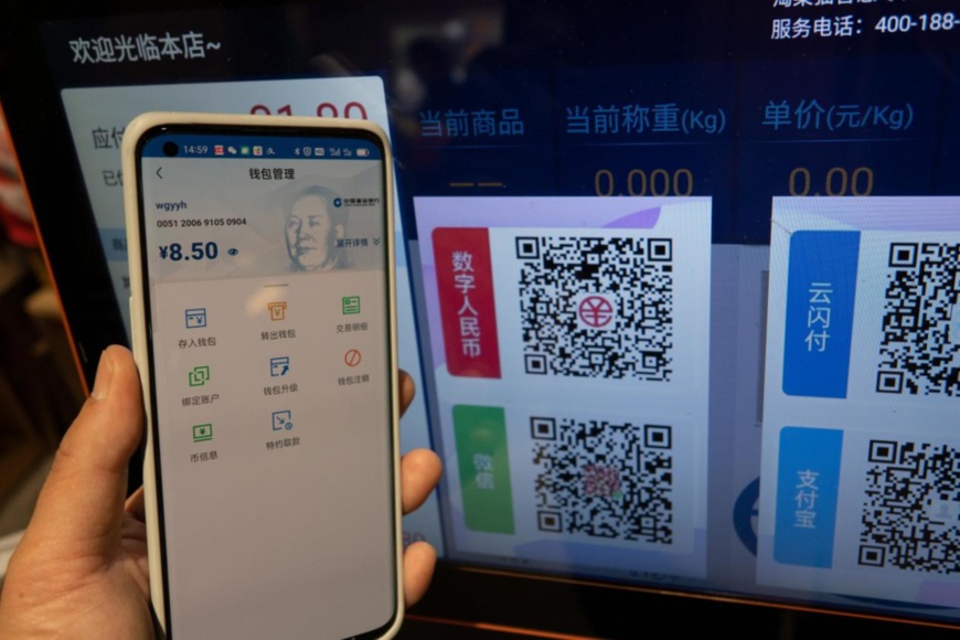 A citizen in Shanghai pays for fruits with digital RMB at a farmers’ market in the city, April 20, 2021. (Photo by Wang Gang/People’s Daily Online)