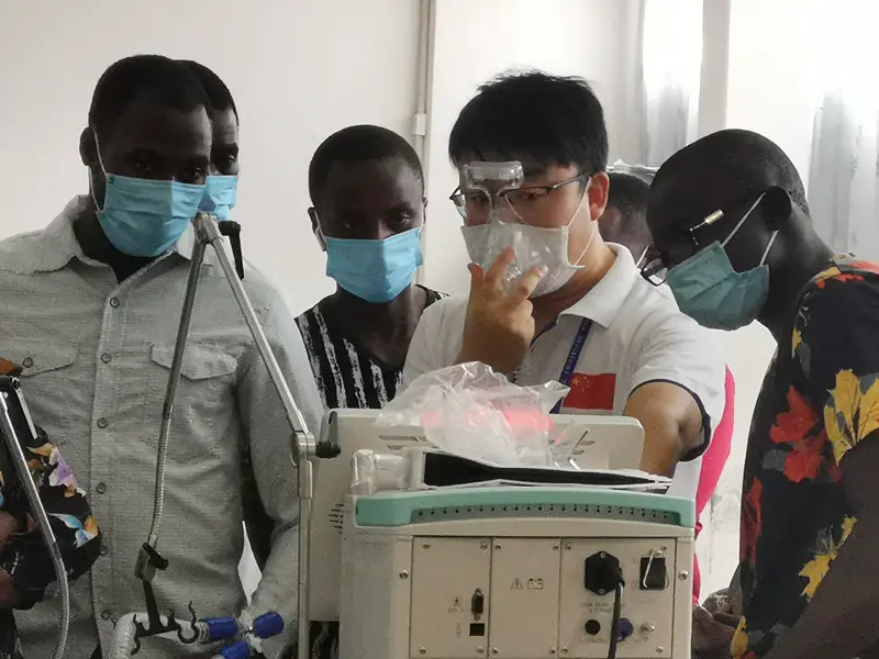 A medical worker from a Chinese medical team dispatched to Gambia instructs local medical staff to use respiratory machines, Jan. 7, 2021. (Photo courtesy of the Chinese medical team dispatched to Gambia)