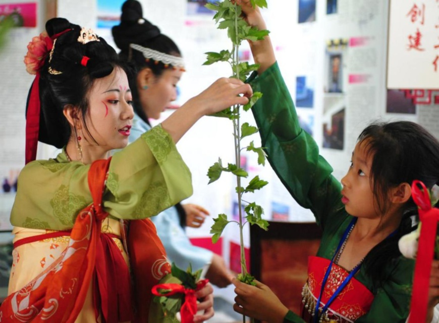 A primary school student learns to make wormwood decorations for the Dragon Boat Festival in Cangzhou, north China’s Hebei province, June 10, 2021. (Photo by Yuan Liwei/People’s Daily Online)