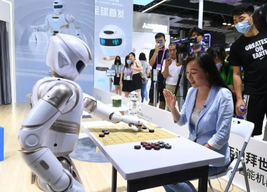A visitor plays Chinese chess with a humanoid robot during the warm-up for the 2021 World Artificial Intelligence Conference (WAIC) held in east China’s Shanghai, July 7, 2021. (Photo by Yang Jianzheng/People’s Daily Online)