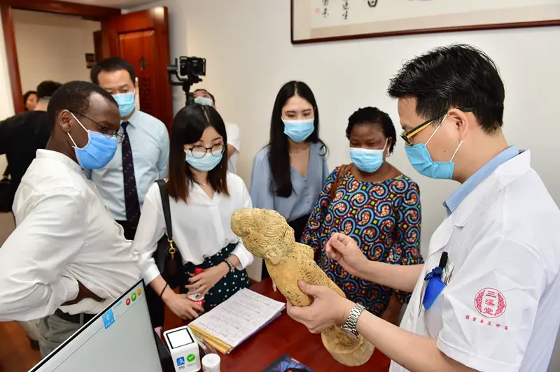 Photo taken on June 13, 2020, shows a traditional Chinese medicine (TCM) doctor explaining TCM acupuncture and moxibustion to a group of visitors led by Edwin Limo, counselor of the Embassy of Kenya in China at Sanxitang Pharmacy, a time-honored TCM pharmacy in east China’s Zhejiang province. Acupuncture and moxibustion of TCM was listed as UNESCO Intangible Cultural Heritage on Nov. 16, 2010. (Photo by Lyu Bin/People’s Daily Online)